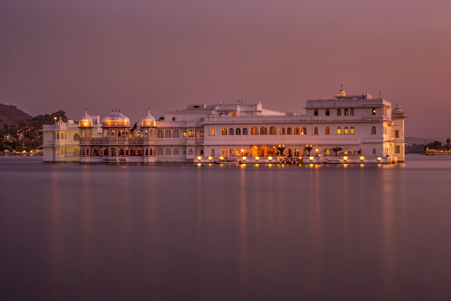 white concrete building near body of water during night time